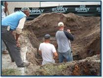 Three men digging a hole